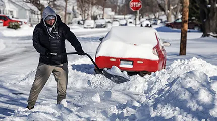 Keaton Fitzgerald uses a snow shovel to dig out of his driveway, Monday, Jan. 26, 2026, in Owensboro, Ky.