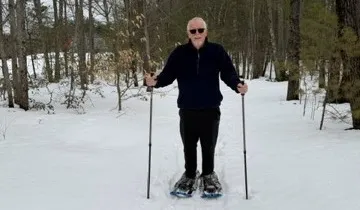 Jeff Lawrence stands in a snowy field, wearing a pair of snow shoes. 